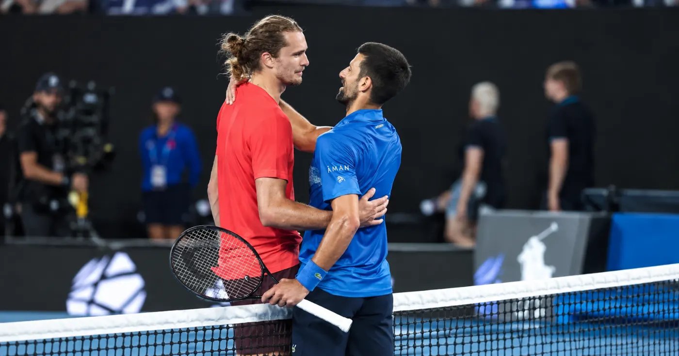 Zverev und Djokovic umarmen sich am Netz am Ende eines Matches