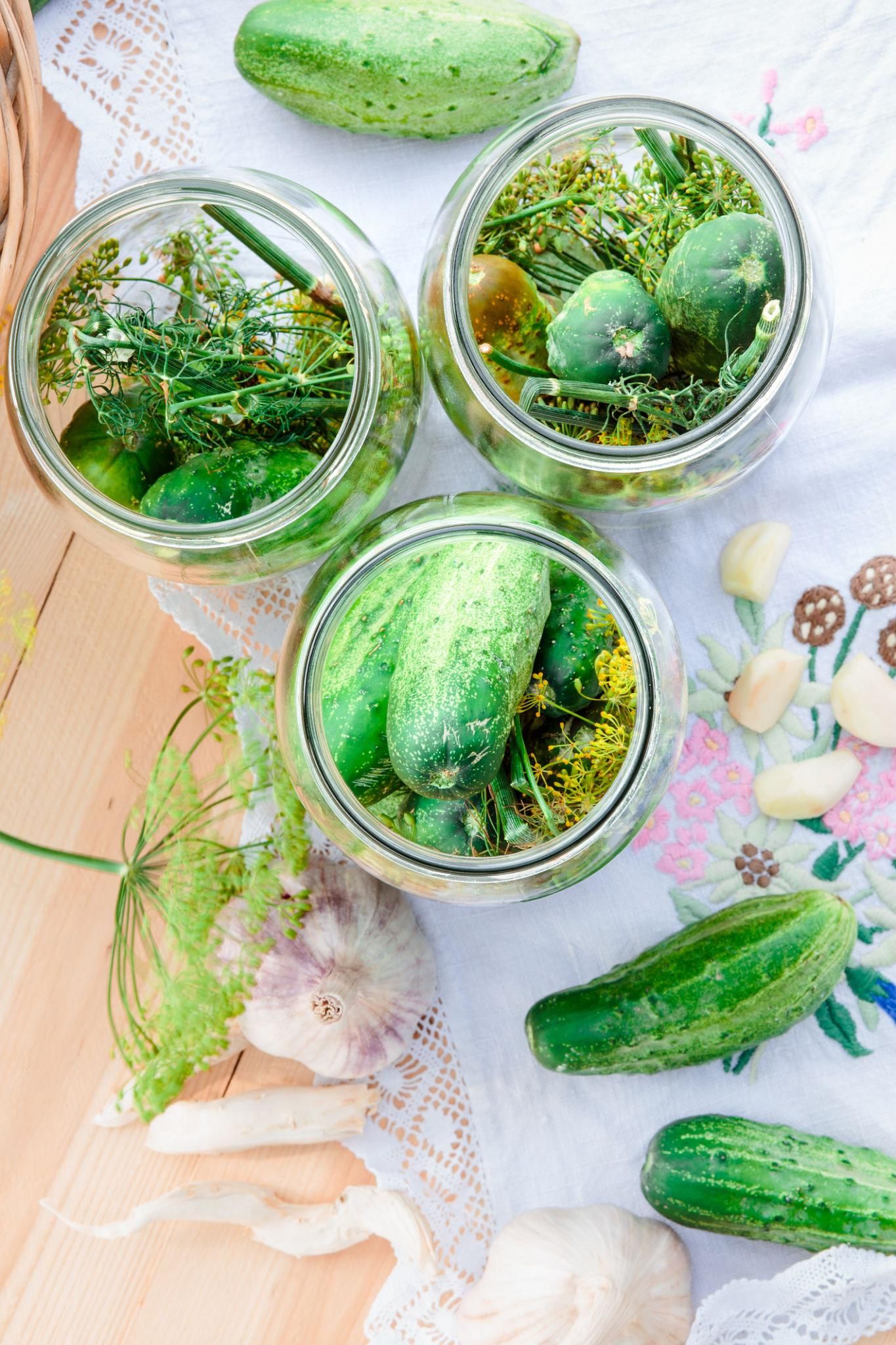 glass jars of small cucumbers on a table