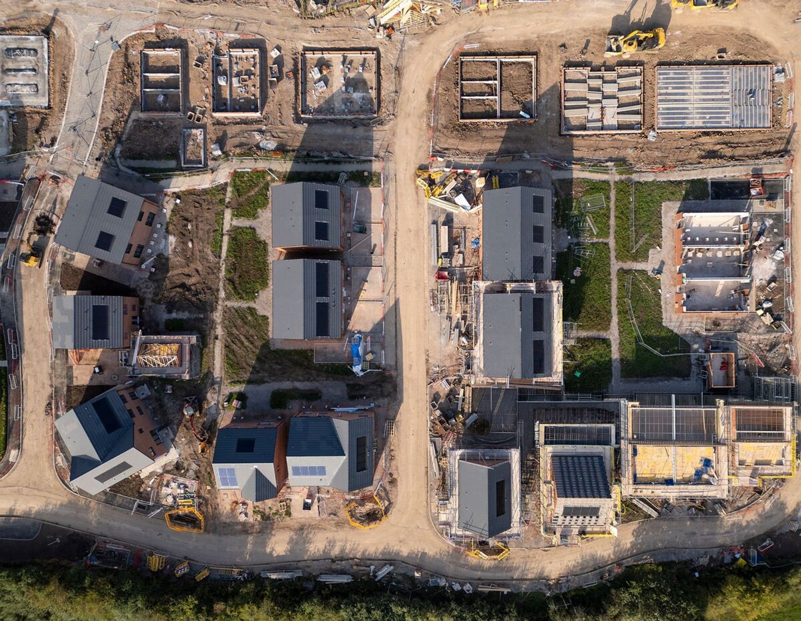 Aerial view of housing development under construction with solar panels being integrated into new builds