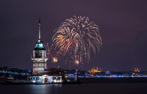 Artificii de Revelion lângă Turnul Fecioarei din Istanbul, cu orașul luminat în fundal.