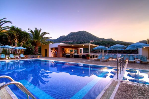 Piscină elegantă cu umbrele albastre, palmieri, pe fundalul unui peisaj montan la apus. Atmosferă de relaxare.