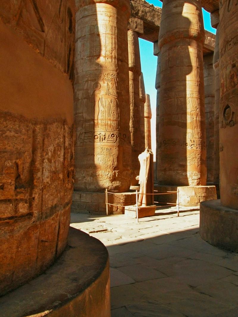 Coloane antice din Templul Karnak din Luxor, Egipt, acoperite cu hieroglife și lumină caldă.