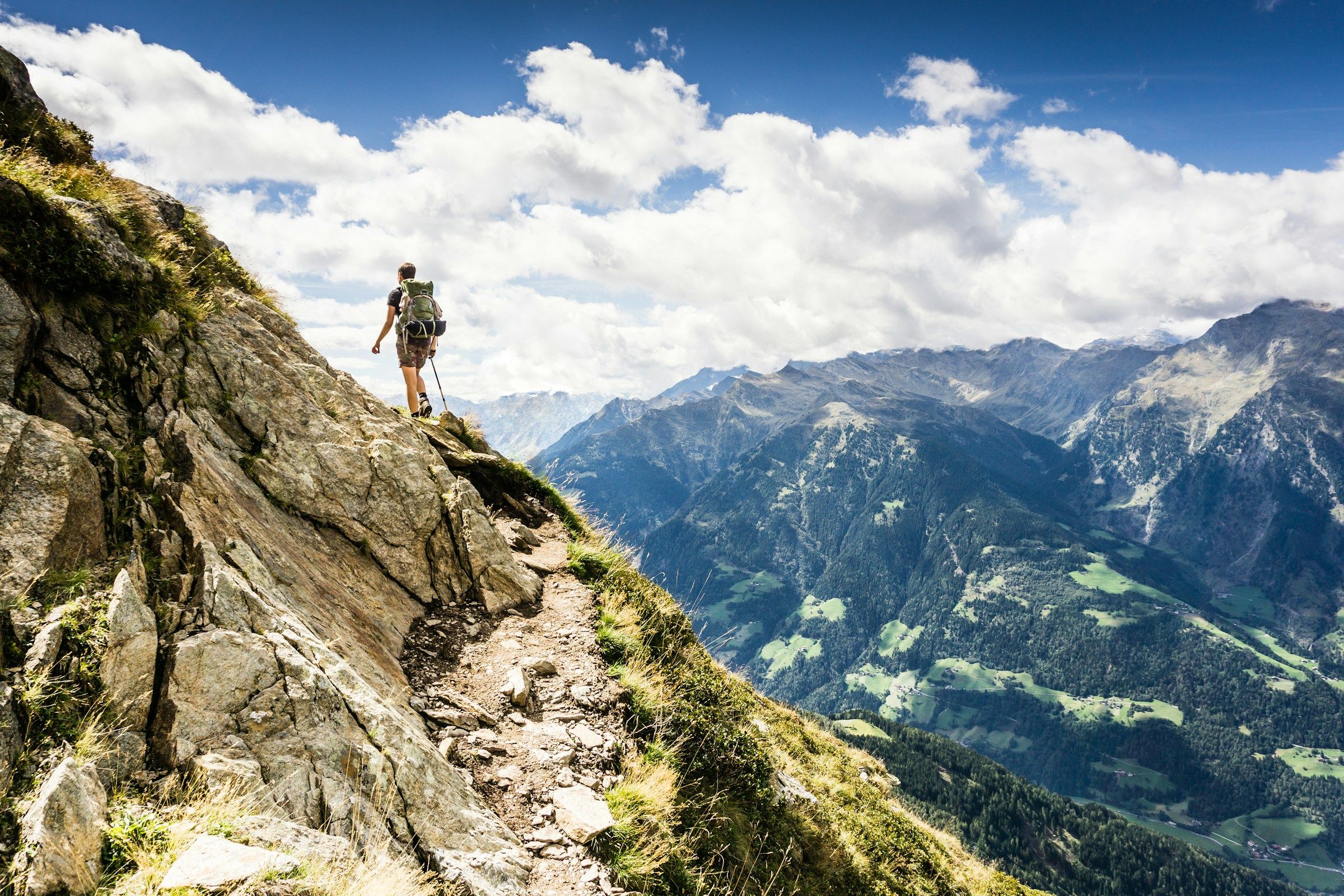 A hiker on a mountain path in the Italian Alps