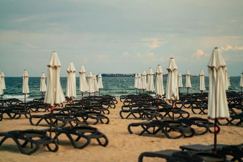 Șezlonguri și umbrele pliate pe plaja Sunny Beach din Bulgaria, lângă Marea Neagră.