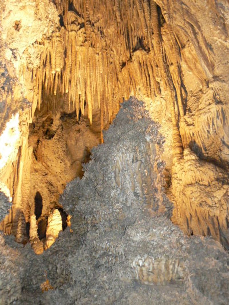 Peștera Uhlovitsa din Bulgaria cu stalactite luminate, formând pereți spectaculoși subterani.