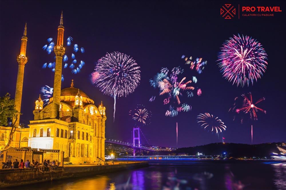 Focuri de artificii de Revelion peste Moscheea Ortaköy și Podul Bosfor din Istanbul, reflectate în apele nocturne.