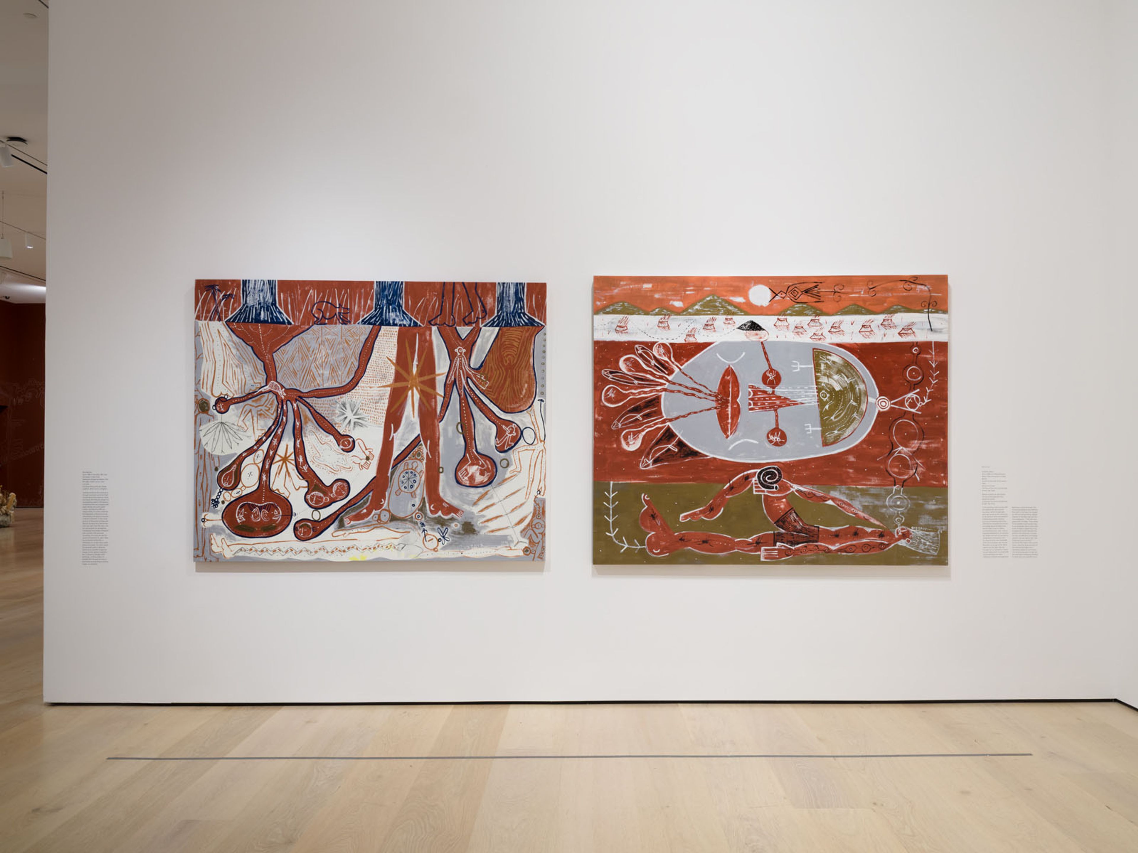 Two large abstract paintings with biomorphic and figurative elements in earthy tones hang on a white gallery wall.