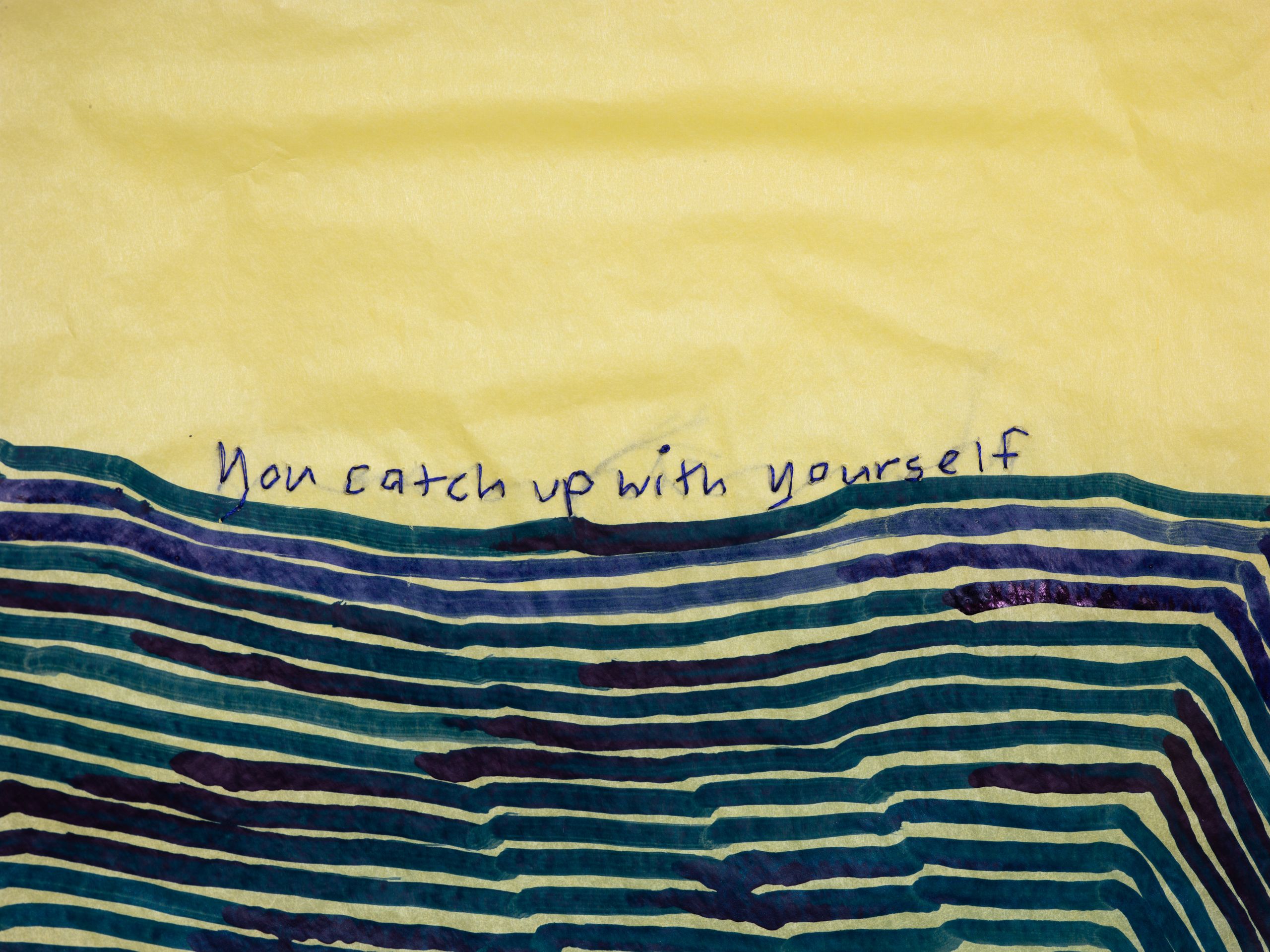 Yellow fabric with the handwritten text "You catch up with yourself" above abstract blue and green lines.