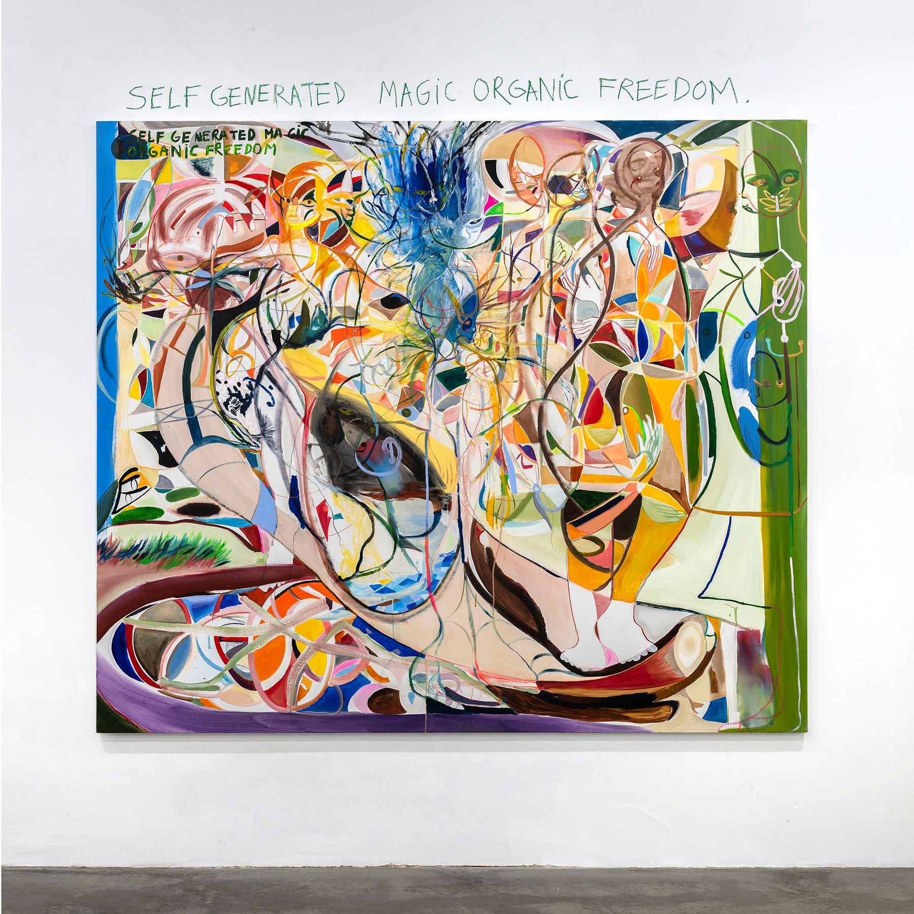 Colorful abstract painting on a white wall, featuring organic forms and the text "SELF GENERATED MAGIC ORGANIC FREEDOM" both above and within the artwork.