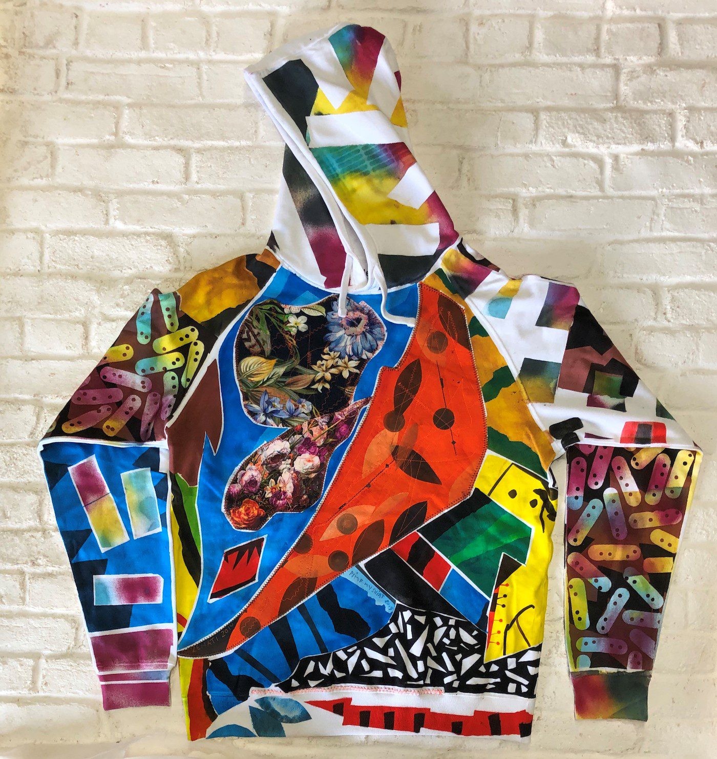 Whereas in the 1980s the artist used colours and forms in a manner that was still somewhat restrained, the designs from his last creative phase from the 2010s until his death are very colourful and dense.
Hamid Zénati, Hoodie, White, XL, 2019/20
Courtesy Hamid Zénati Estate.