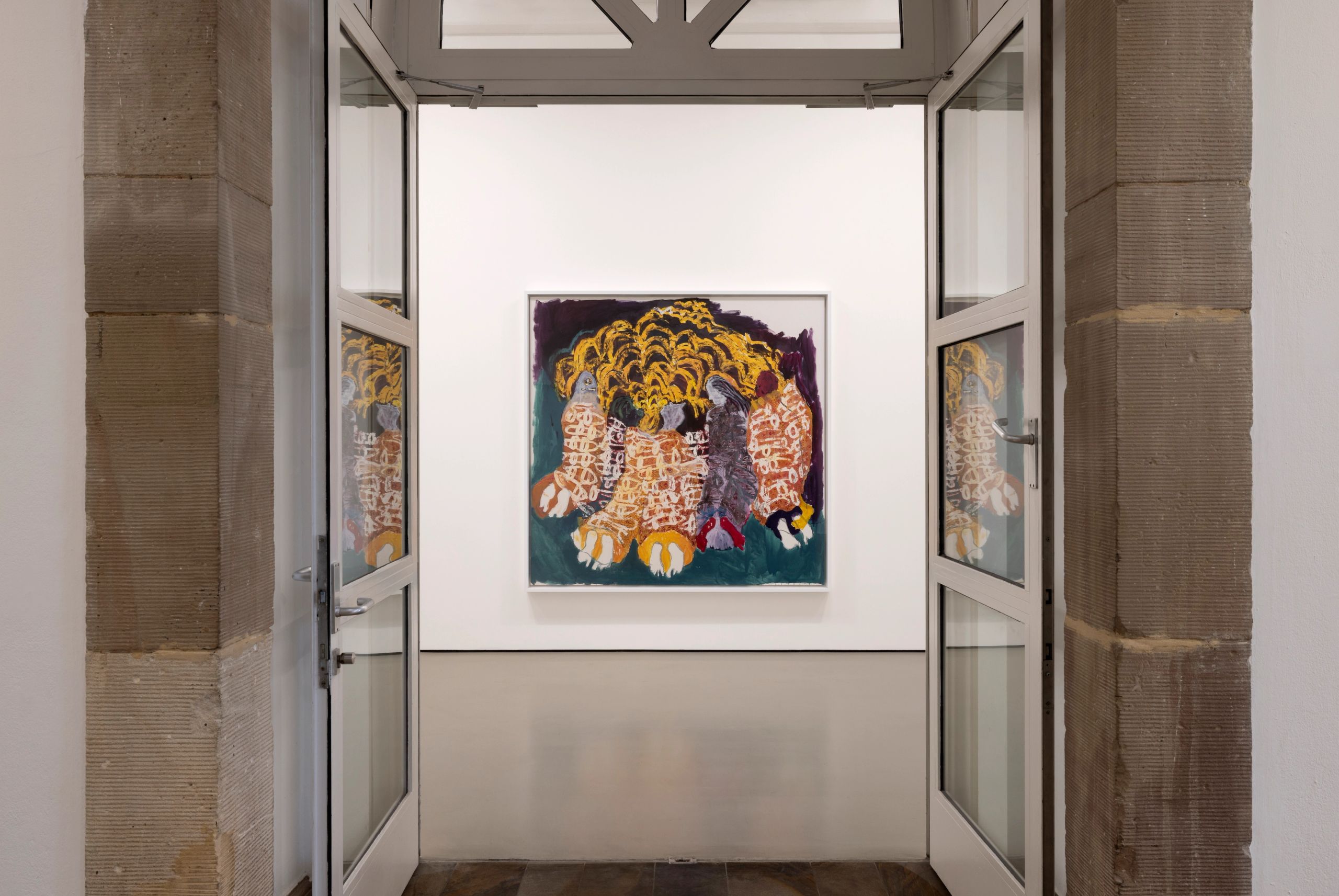 An open stone doorway frames a gallery room with a colorful abstract painting centered on a white wall.