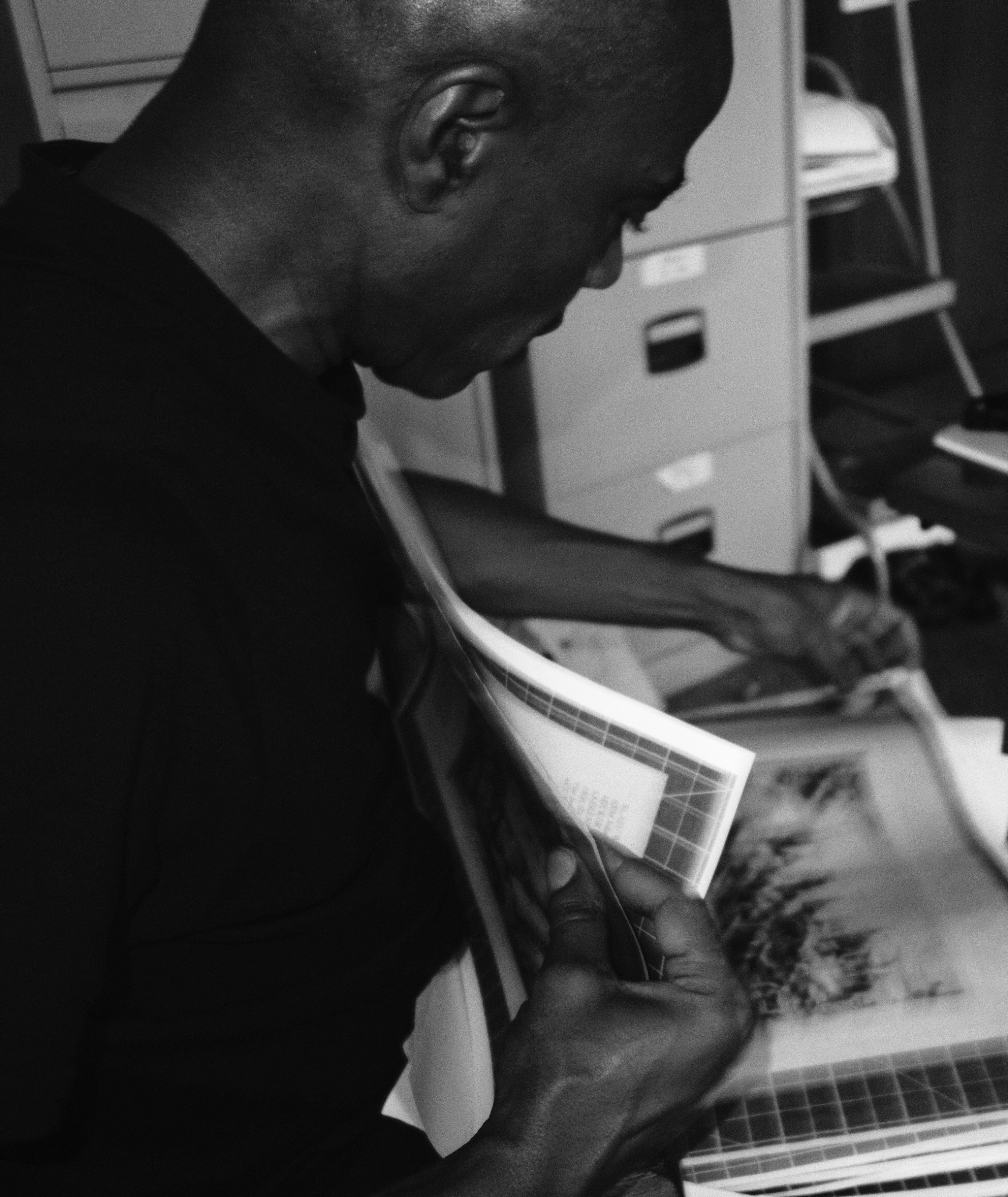 Black and white profile photo of a man looking at an open book.