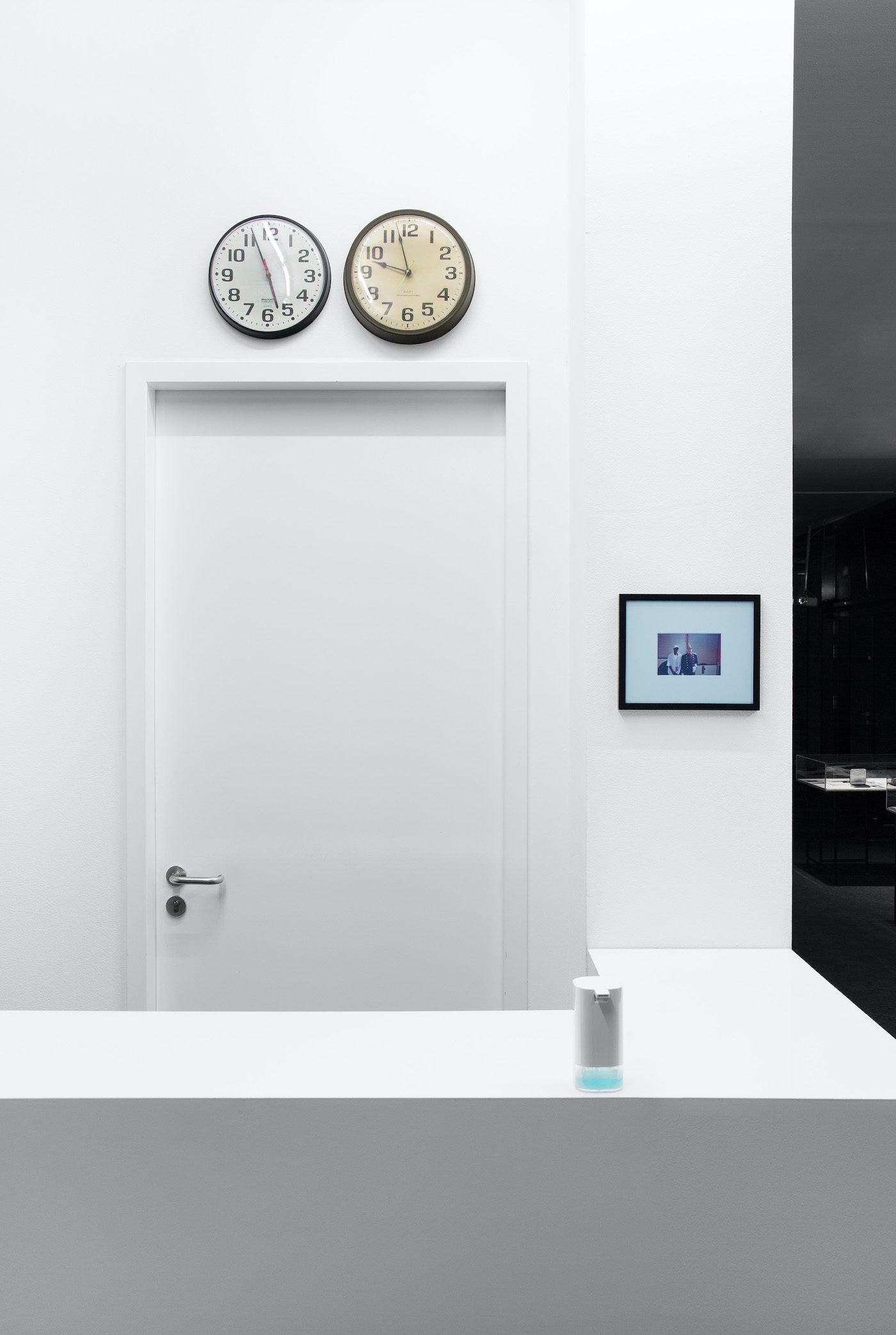 James Gregory Atkinson, CST/CET Office, 2021, clocks, photography, counter, installation view, ‘6 Friedberg-Chicago’, Dortmunder Kunstverein. Courtesy: the artist, Germericans (Sabrina und Marvin Kuhn), Tyrown Vincent, Dortmunder Kunstverein. Photo: Jens Franke