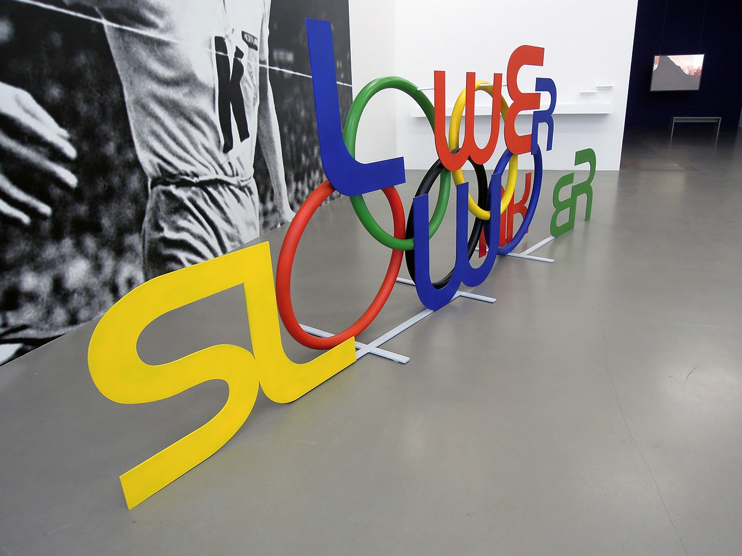 Minerva Cuevas, Weaker Lower Slower (detail). Painted steel and wall photograph, 2019.