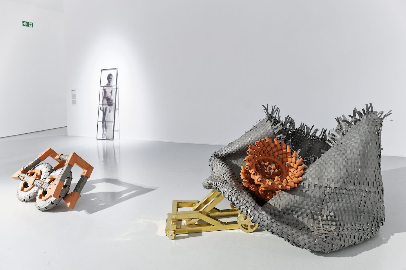 In the foreground, from left to right: Marie Aimée Fattouche, El etnen [Les deux], 2022, earthenware, zinc, brass, threaded roots, bolts, rivets, Collection of the artist; In the background, on the wall: Euridice Zaituna Kala, Model I, 2020, glass. Collection of the artist. View of the exhibition Globalisto. A Philosophy in Flux at the Musée d’art moderne et contemporain de Saint-Étienne Métropole, from June 25th to October 16th, 2022. Crédit photo : C. Cauvet / MAMC+