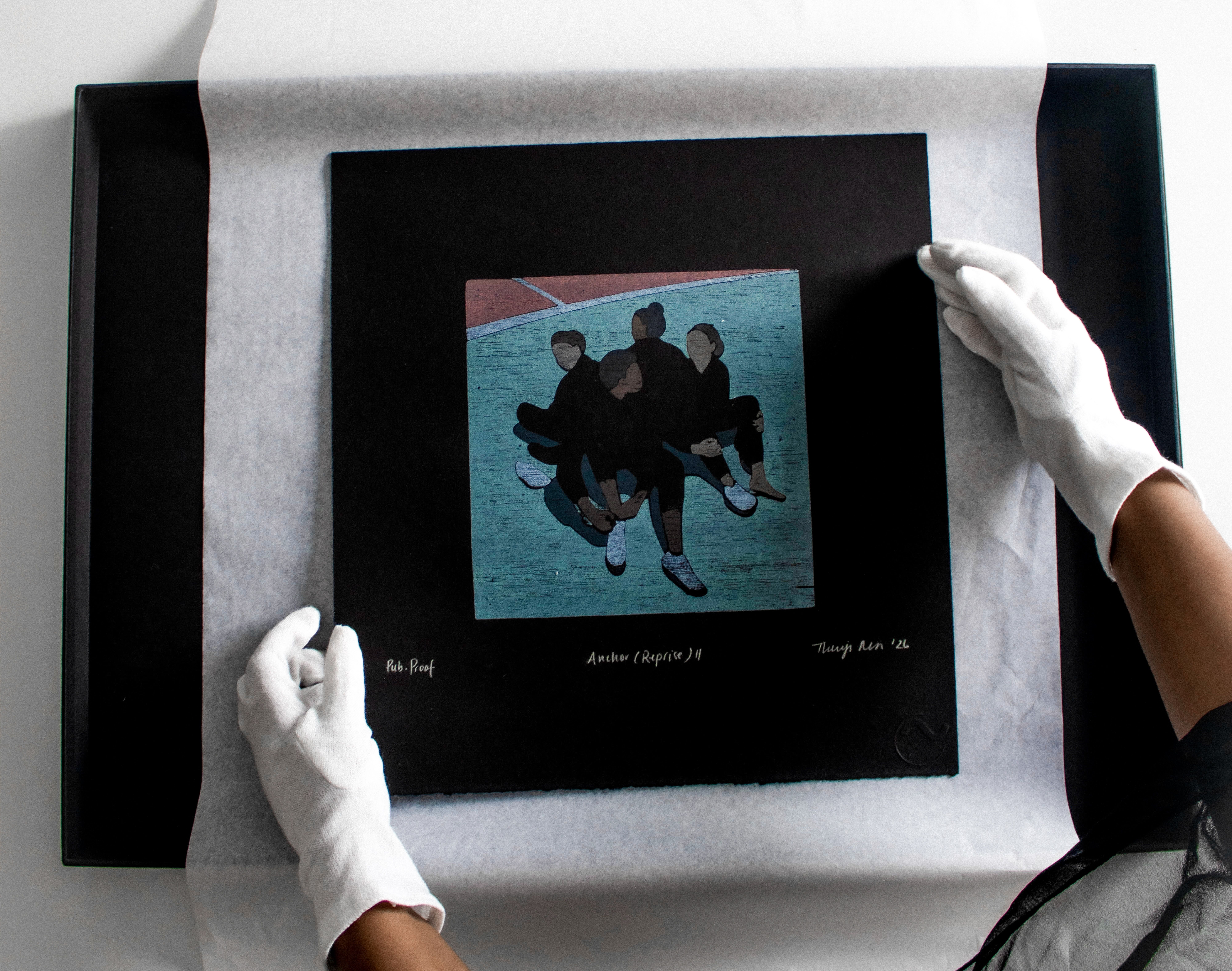 White-gloved hands carefully position a print depicting five figures in a circle within a black frame.