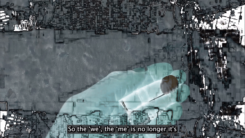 A glowing, translucent blue hand holds a small brown sphere on a stick against a dark, abstract background with the subtitle "So the 'we', the 'me' is no longer it's".