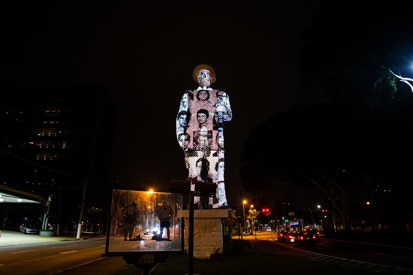 Coletivo Coletores. Edited Strength – Borba Gato Monument, 2020. Video projection on traditional statue of the bandeirante in São Paulo shows photos of the disappeared, deceased and political prisoners from the military dictatorship (1964-1985). Photo: Toni Baptiste.