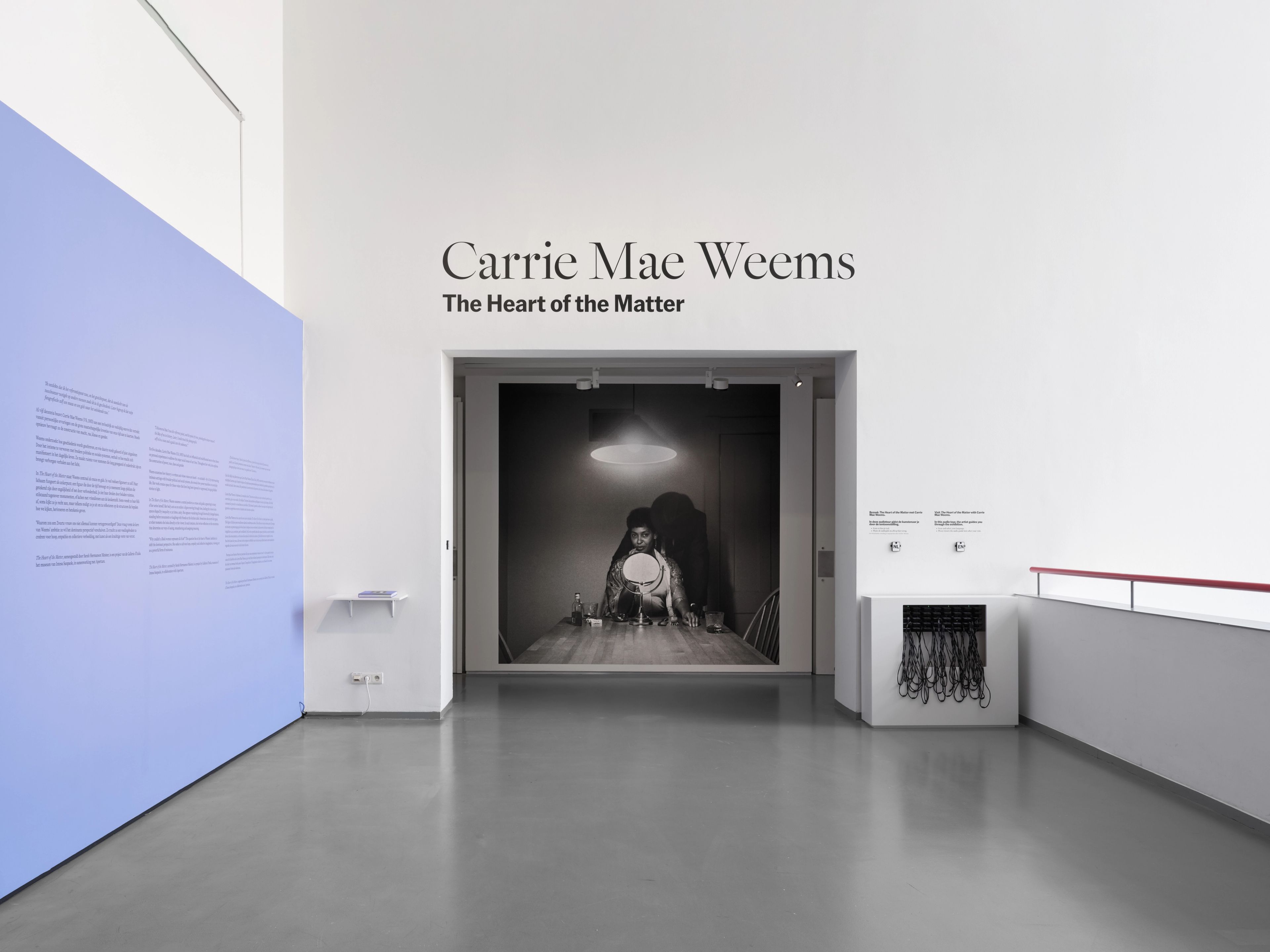 Entrance to the "Carrie Mae Weems: The Heart of the Matter" exhibition, featuring a large black and white photograph in the doorway and a blue text panel.
