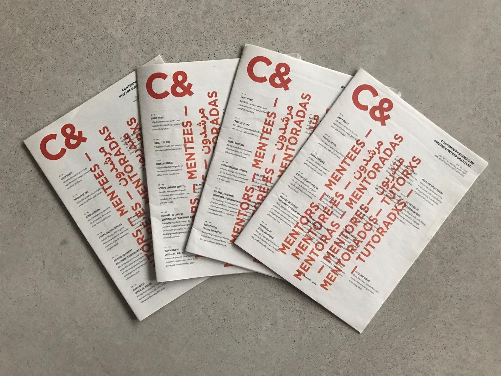 Four white publications fanned out on a grey surface, displaying 'C&' and red text like 'MENTORS' and 'MENTEES'.