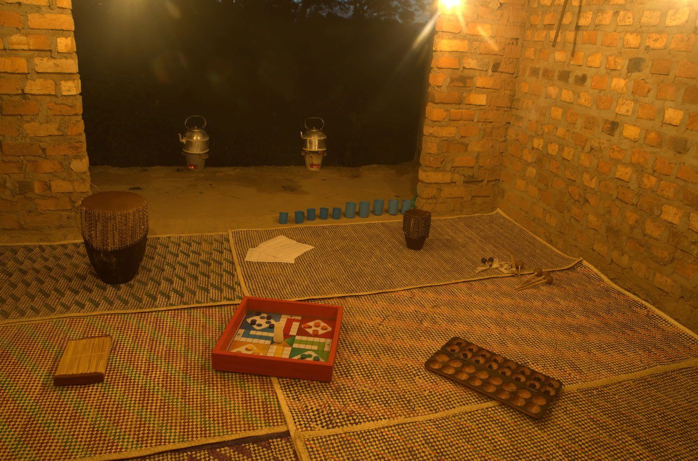 Lisa C Soto, It reminds me of home, 2023, Instruments, games, teapots, cups, foraged leaves, mats, 365 x 275 cm at Silent Invasions: The Art of Material Hacking. Photo: Wasswa James