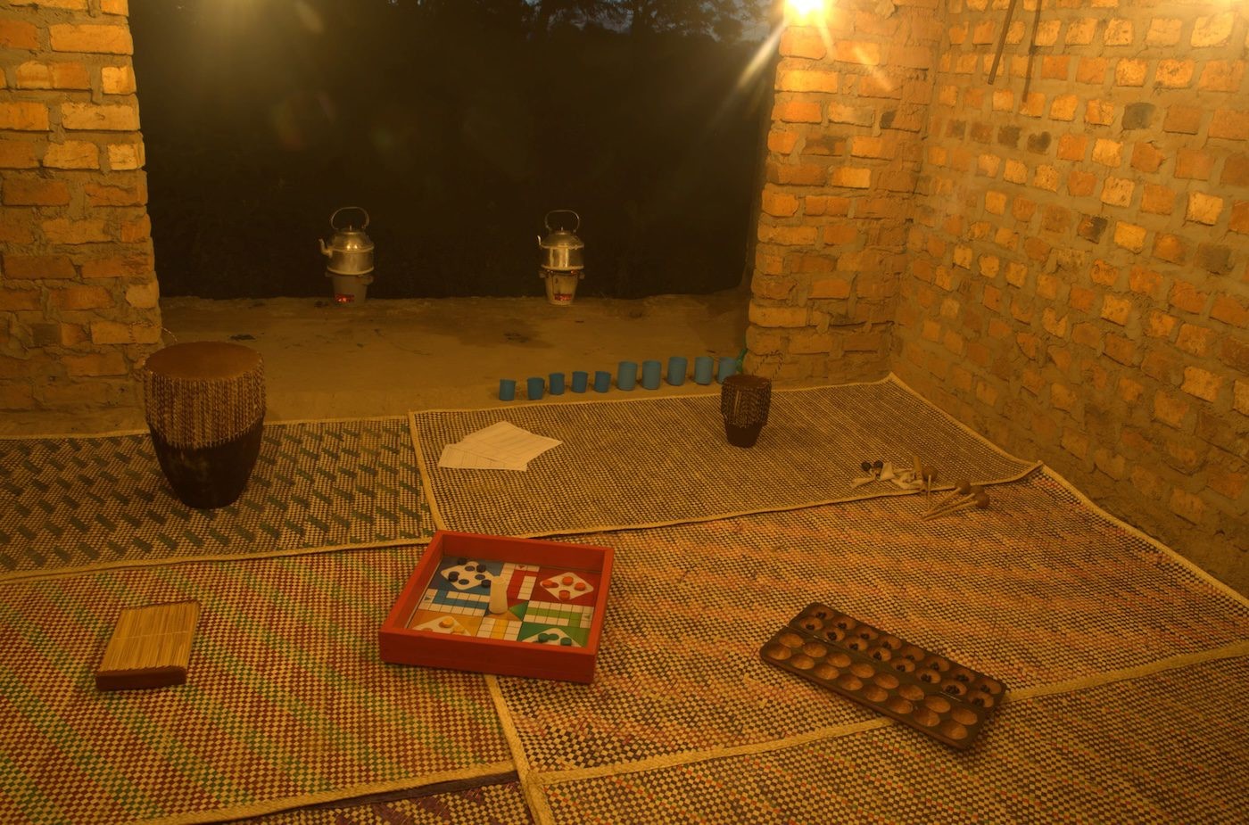 Lisa C Soto, It reminds me of home, 2023, Instruments, games, teapots, cups, foraged leaves, mats, 365 x 275 cm at Silent Invasions: The Art of Material Hacking. Photo: Wasswa James