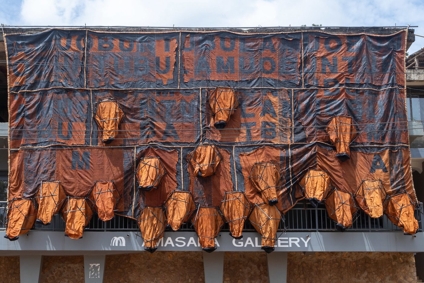 Childhood memoir, 2023, installation from barkcloth, bamboo, cotton, sisal, acrylic paint, nylon, thread, 620 x 1240 x 100 cm. Photo: Wasswa James