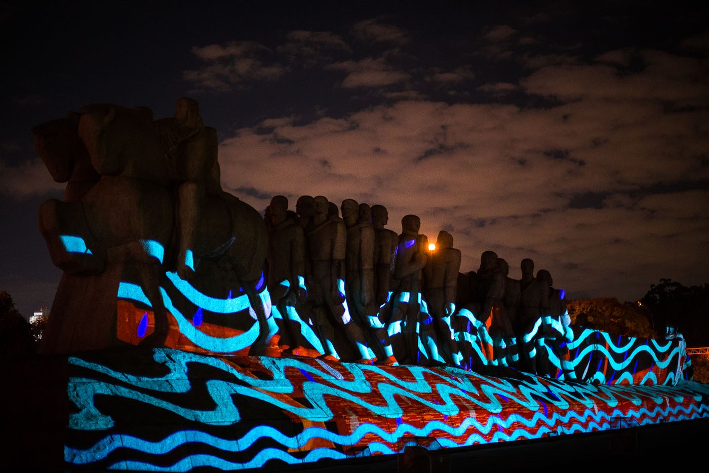 Coletivo Coletores and Denilson Baniwa. Voices Against Racism, 2020. Video projection of works by indigenous artist Denilson Baniwa on a monument in São Paulo praising the acts of the Bandeirantes frontiersmen. Photo: Toni Baptiste.