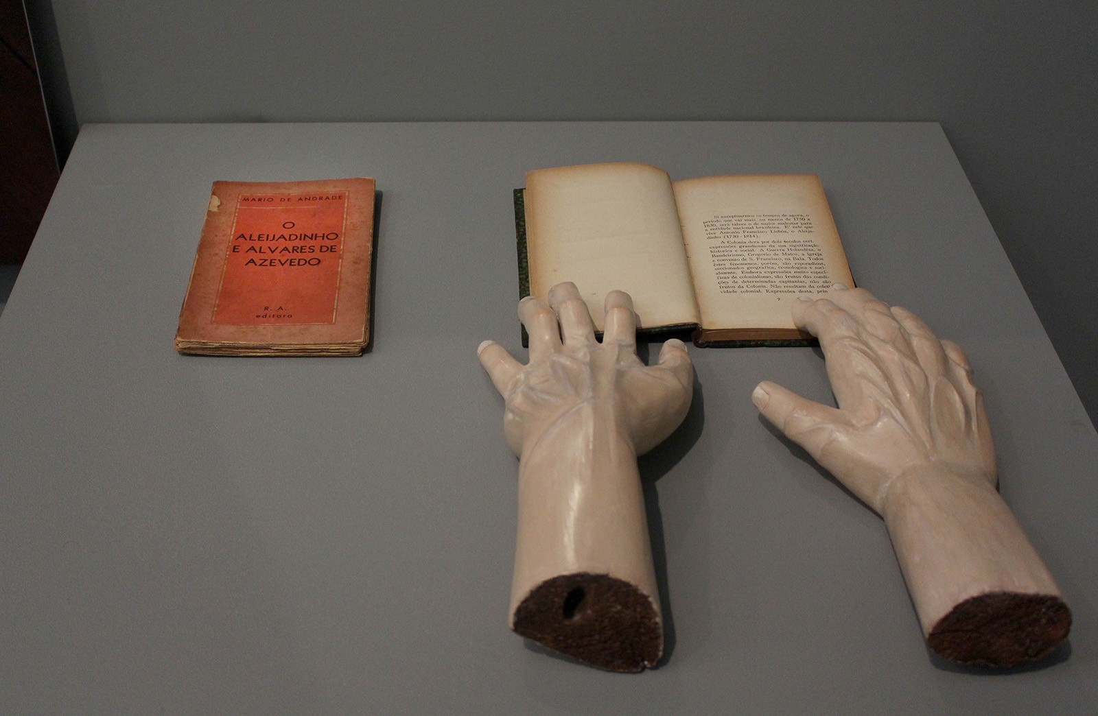 Thiago Honório, Estudo para leituras, 2015-18. First edition of the bookO Aleijadinho e Alvares de Azevedo (1935), by Mário de Andrade; stone hands (19th century), Artist's collection.