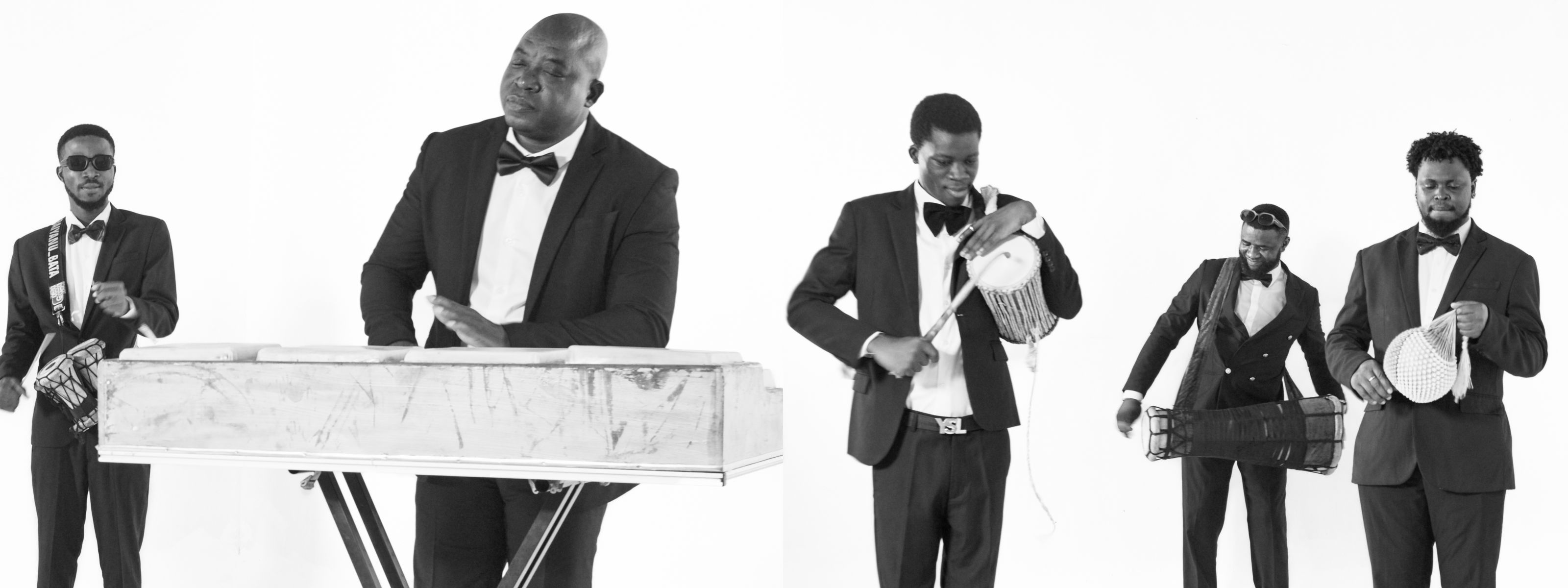 Black and white photo of five men in suits and bow ties playing various musical instruments, including a keyboard, talking drum, and percussion.