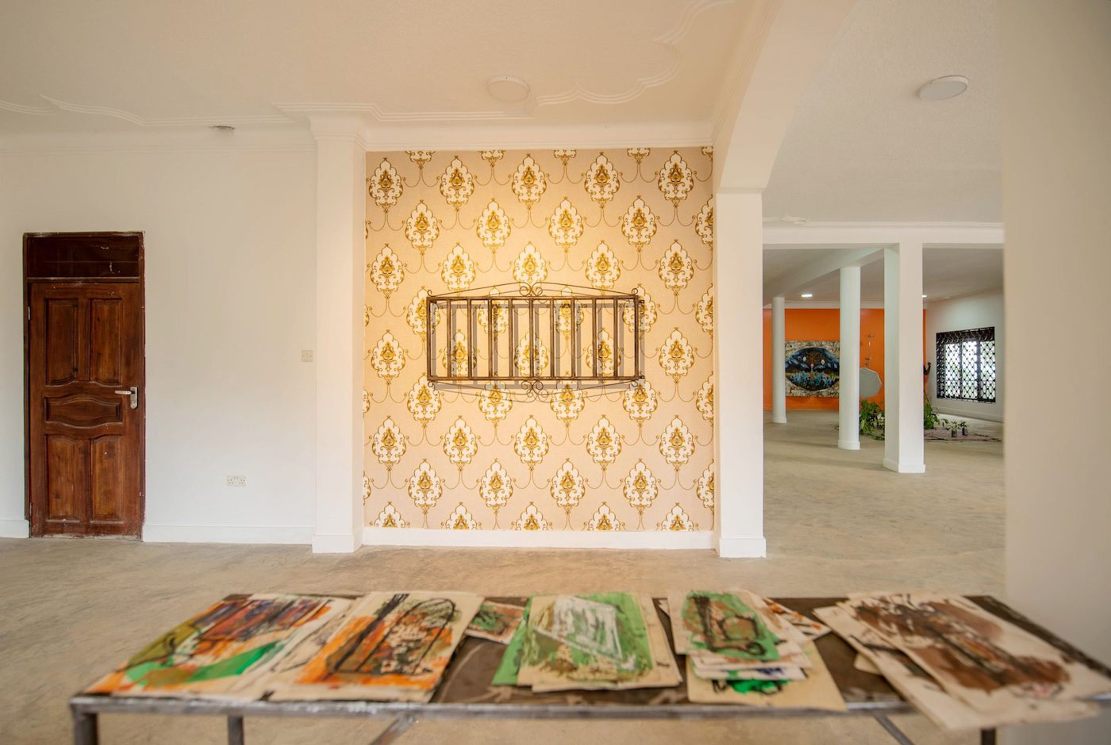 Hassan Issah, Lyrical Opulence, 2023, locally welded iron cage on wallpaper, variable dimensions and An old story, 2023, 52 works on paper on locally welded table at Silent Invasions: The Art of Material Hacking. Photo: Atiko Anthony