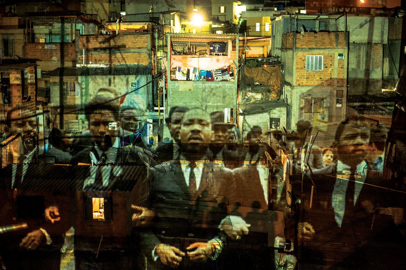 Coletivo Coletores RESIST! 1.0, 2014. Video projection of images from the march of Civil Rights leader Martin Luther King Jr. (1929-1968) in Selma (USA) onto houses in the Vila Flávia community, on the outskirts of São Paulo. Foto: Toni Baptiste.
