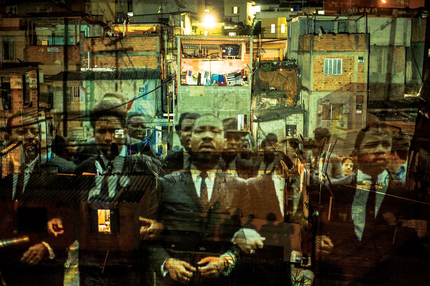 Coletivo Coletores RESIST! 1.0, 2014. Video projection of images from the march of Civil Rights leader Martin Luther King Jr. (1929-1968) in Selma (USA) onto houses in the Vila Flávia community, on the outskirts of São Paulo. Foto: Toni Baptiste.