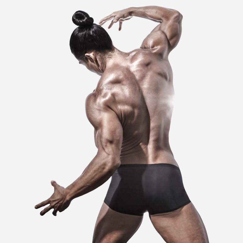 Dominate - Model in dynamic pose wearing dark blue briefs