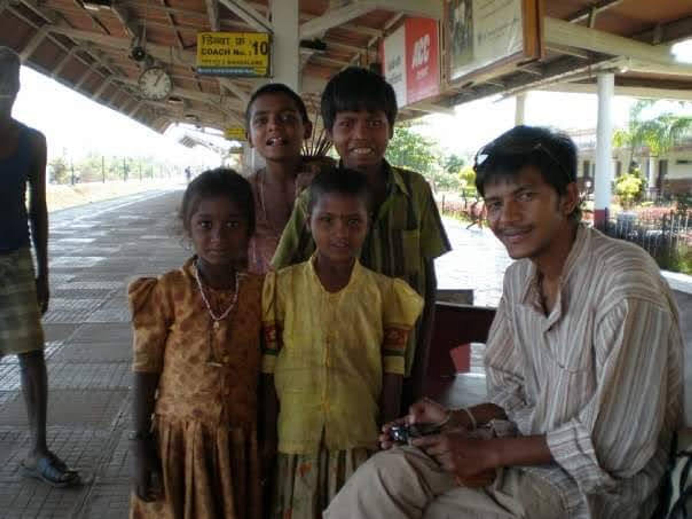 Saroj Khadgi sitting with children on a station platform