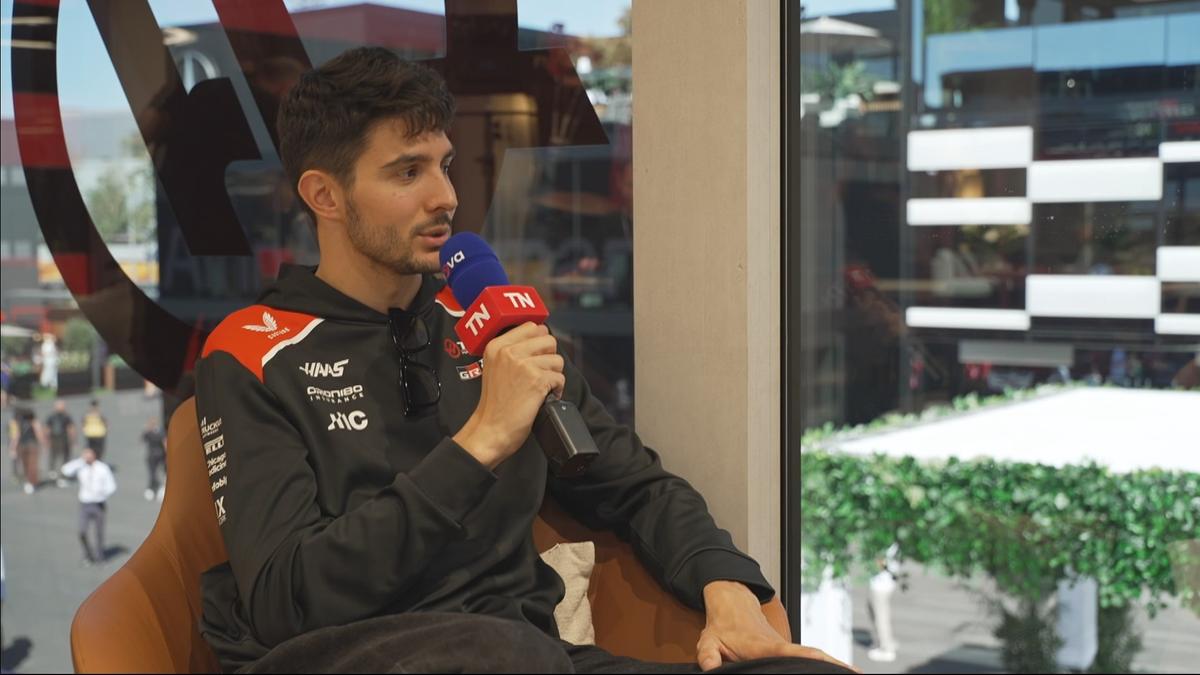 Esteban Ocon sedí při rozhovoru a drží mikrofony Nova Sport a TN.