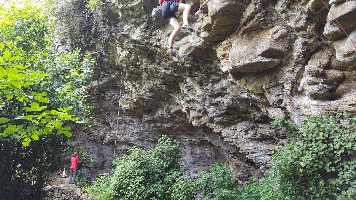 Rock climber and spotter at rocky cliff