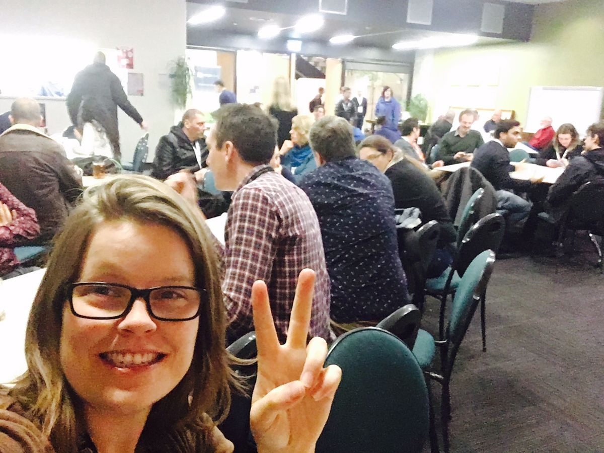 Woman selfie, peace sign, people behind
