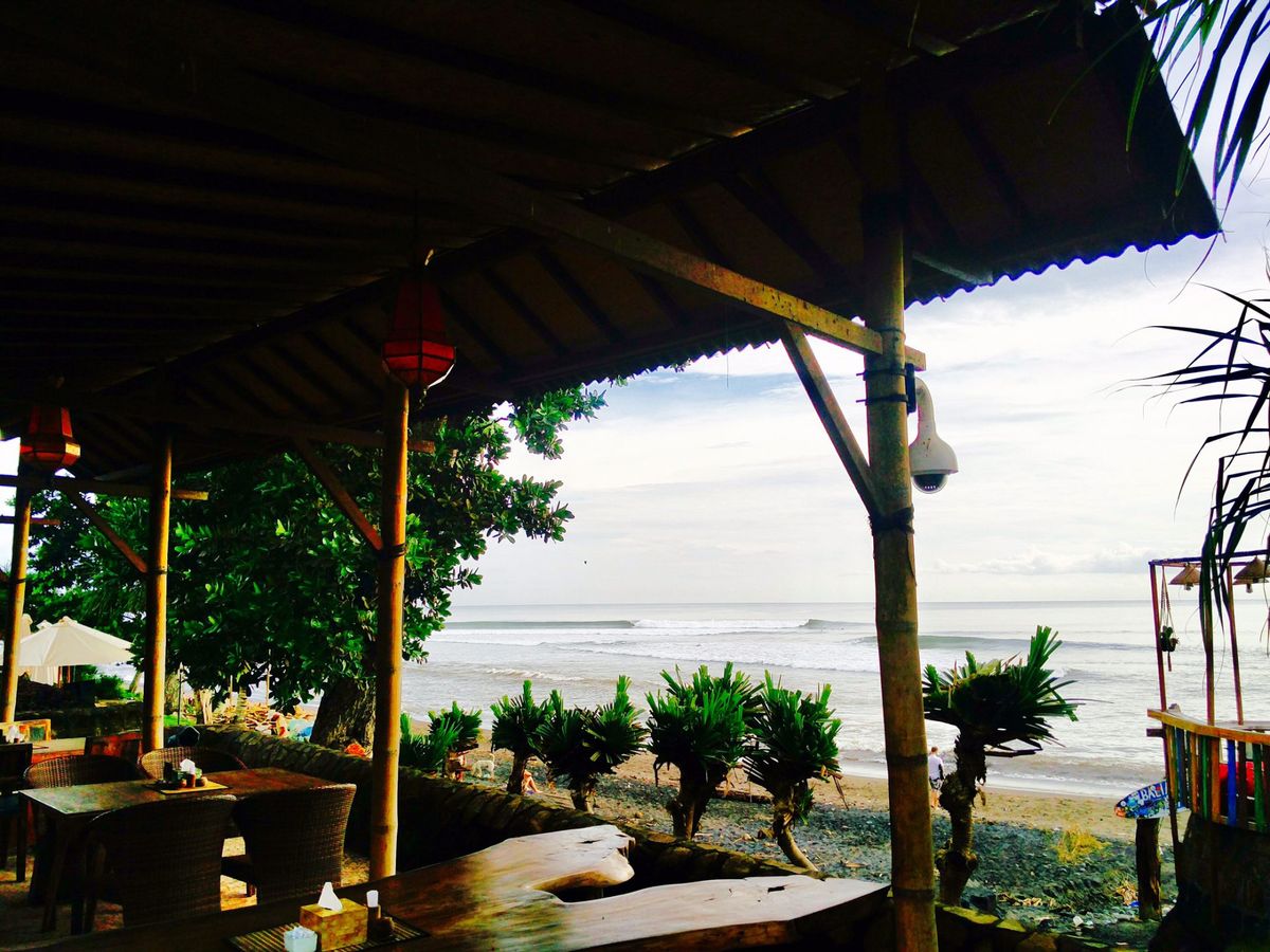 Looking out to the ocean, over the beach from inside a restaurant on the beach.