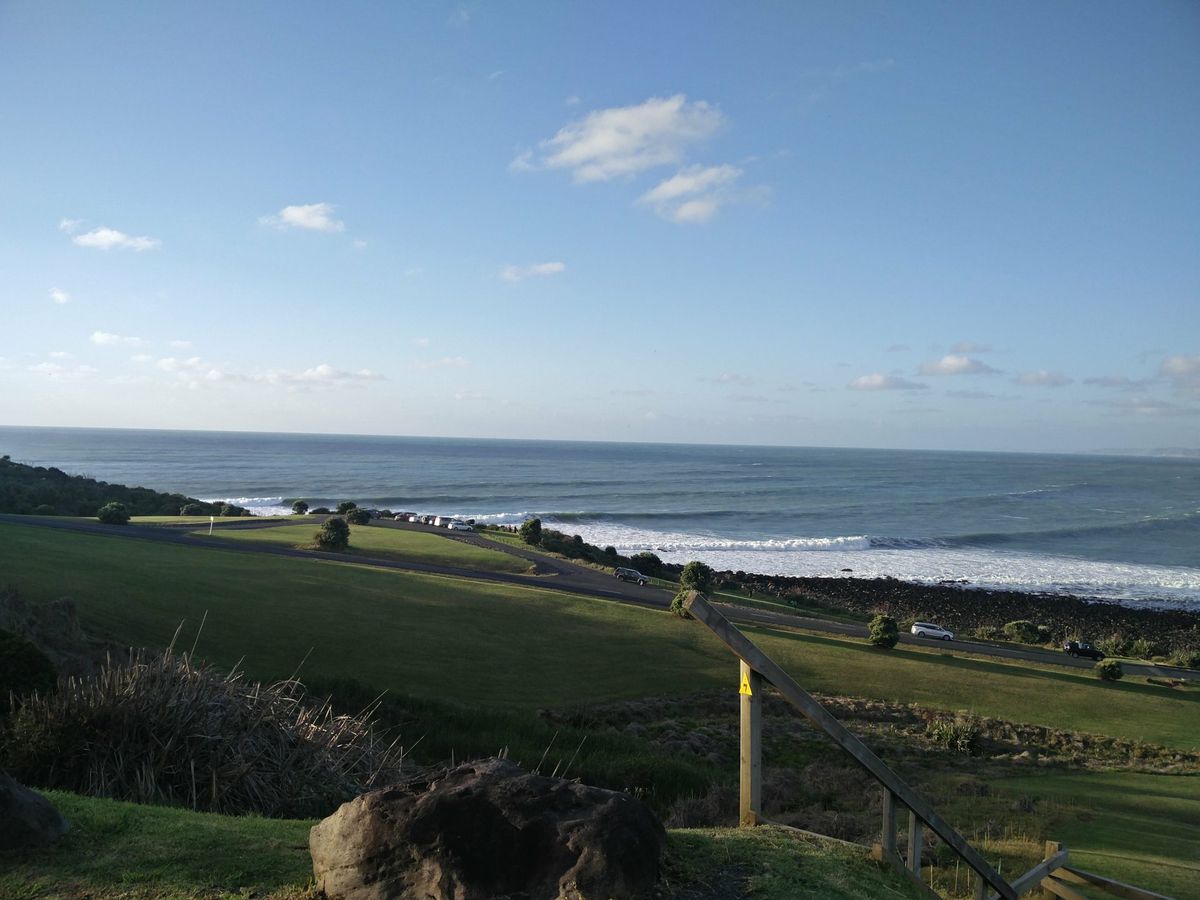 Looking out towards Manu Bay; view of green hills and ocean
