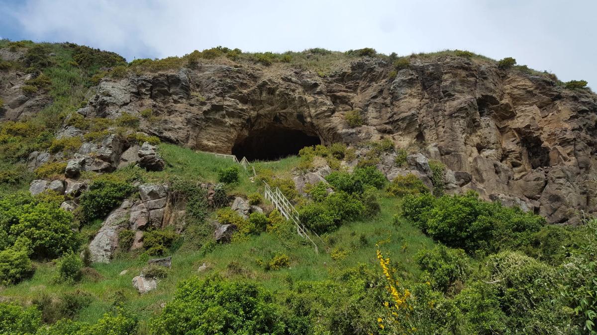 Rocky cliff with cave and handrail path