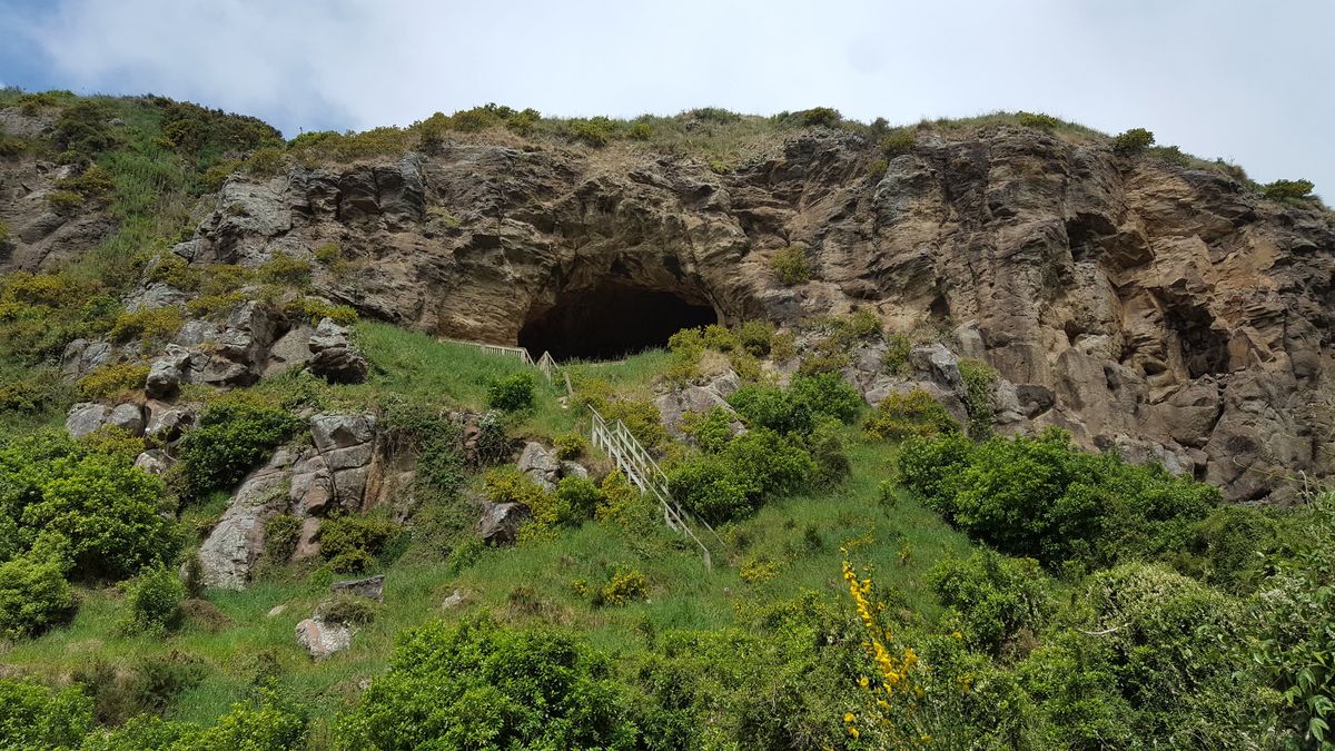 Rocky cliff with cave and handrail path