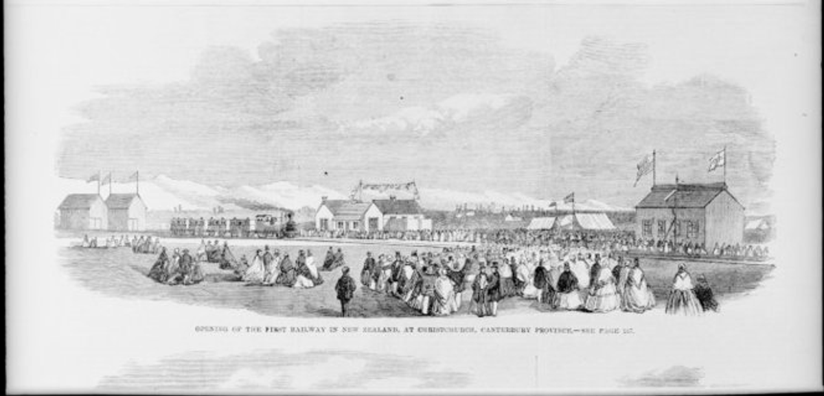 Black and white photo, buildings, railway and crowd in field
