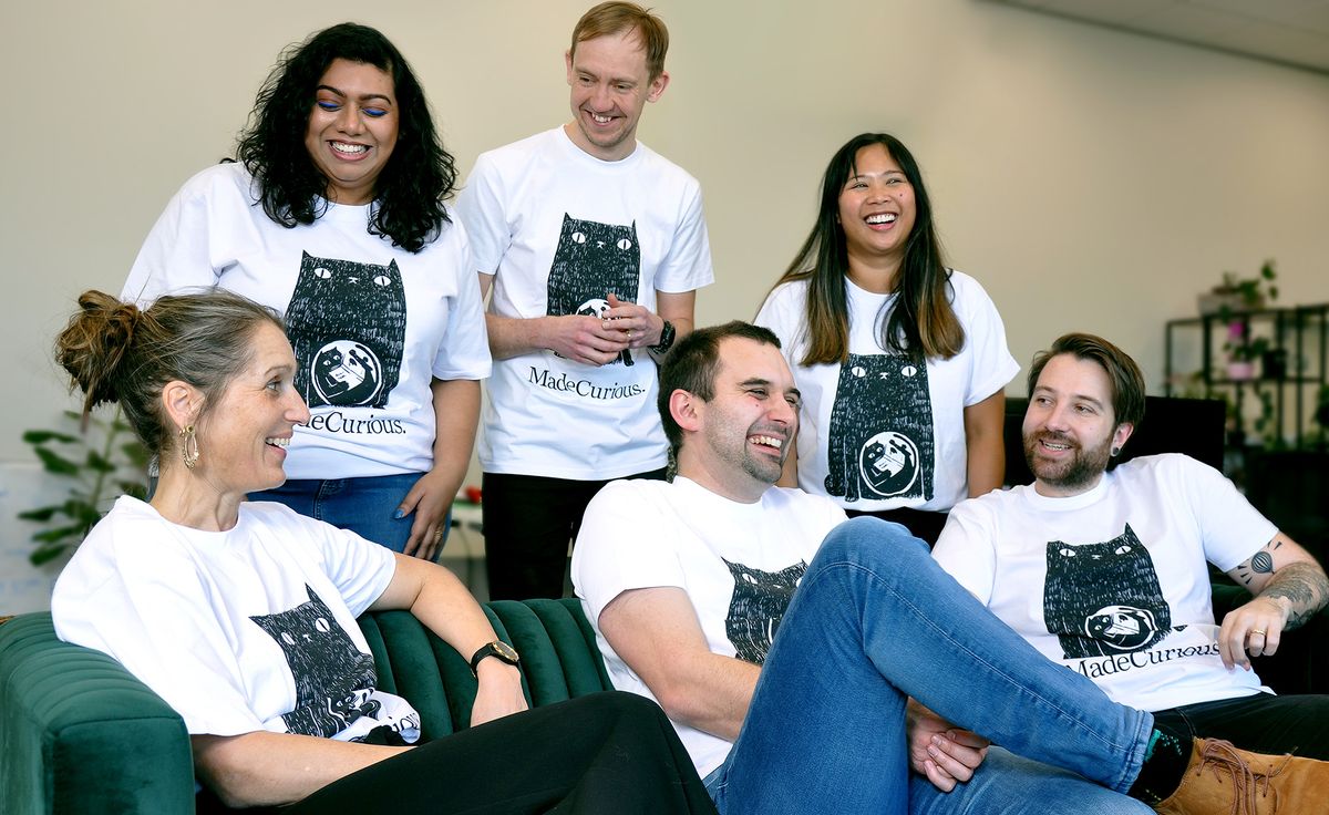 A group of MadeCruious people sitting  and talking on a couch