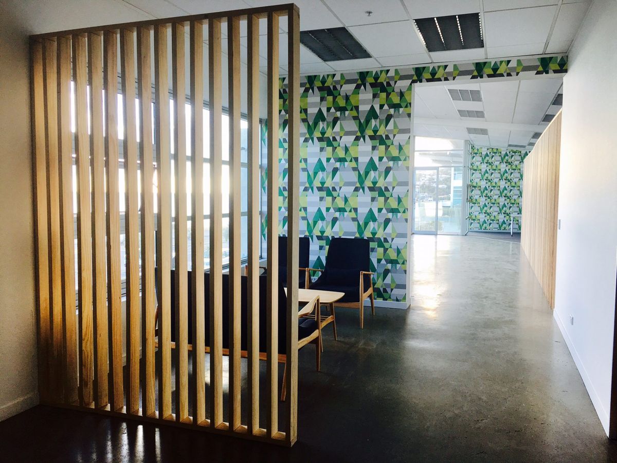 View along the corridor of an office, small reception space in the foreground.
