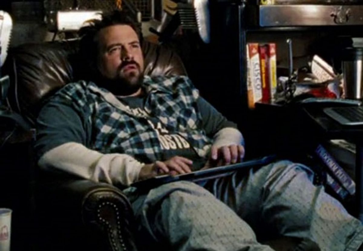 Man in a reclining leather armchair with a computer keyboard on his lap