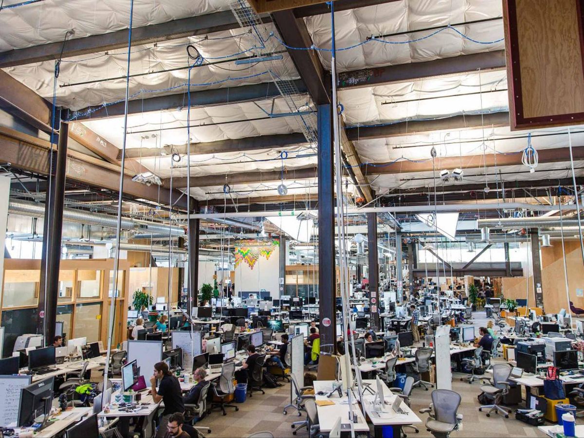 Open plan office with desks, cables from ceiling
