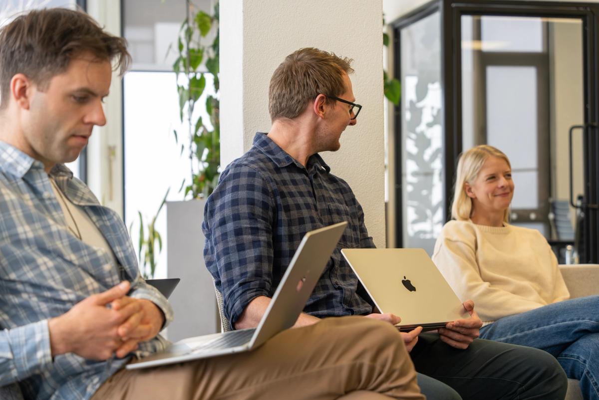 Three people sitting in a row talking to each other