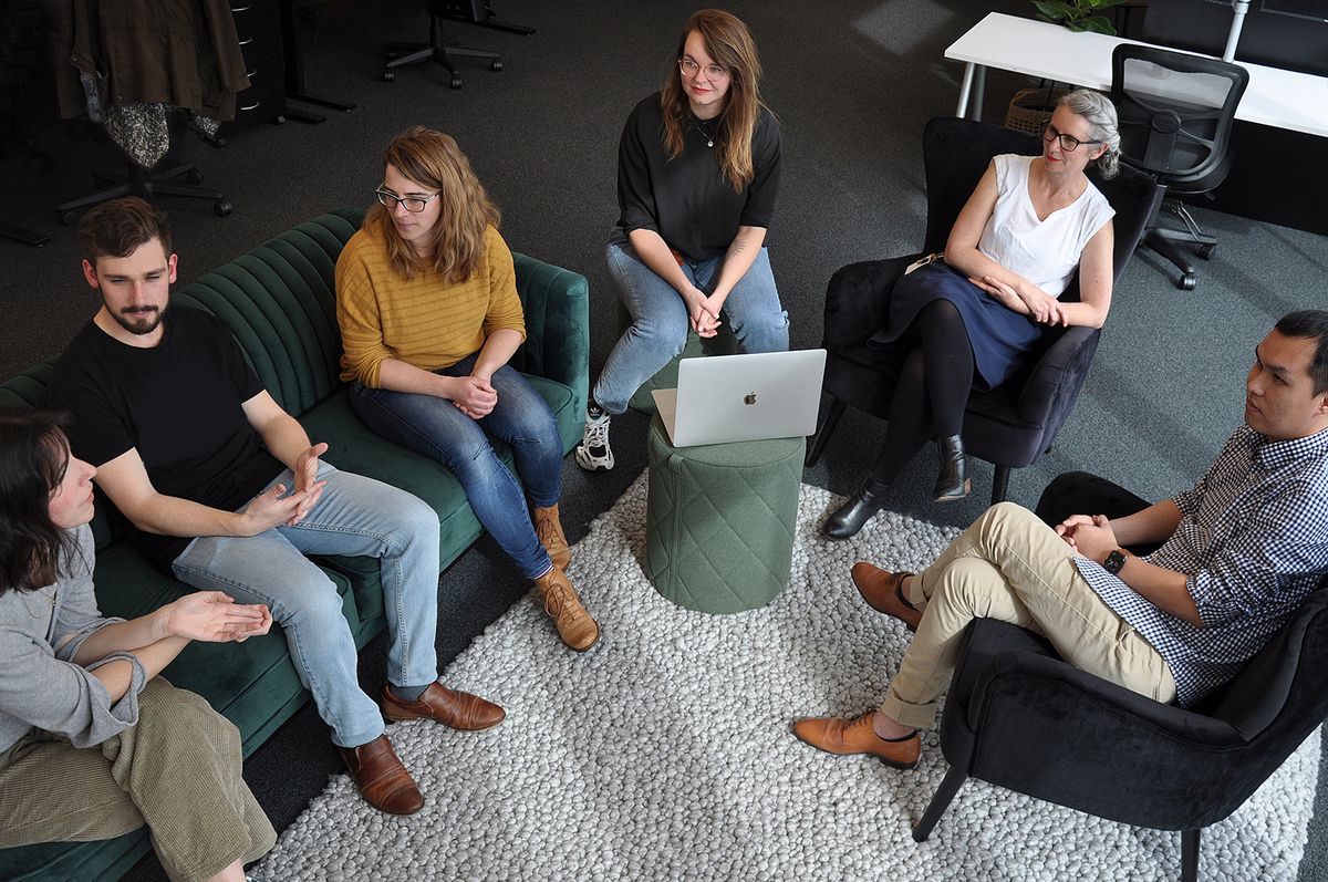 A group of MadeCruious people sitting and talking on a couch