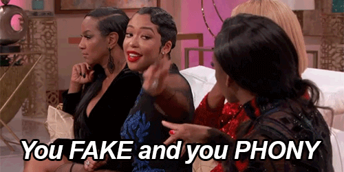 Gif of four women sitting on a couch, one woman points at another woman saying You fake, and you phoney